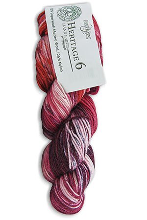 A skein of multicolored yarn labeled "Heritage 6" is shown. The yarn has varying shades of red, pink, and white. The label indicates that it is made of 75% Superwash Merino Wool and 25% Nylon.
