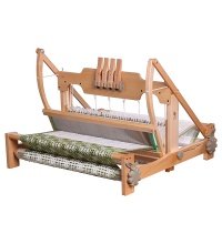 A wooden weaving loom with several threads in place is shown. The loom has multiple components including a heddle, beater, and warp beam, and appears ready for creating fabric.