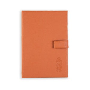 A set of four leather notebooks, one is pink, one dark brown, one light grey, and one orange.