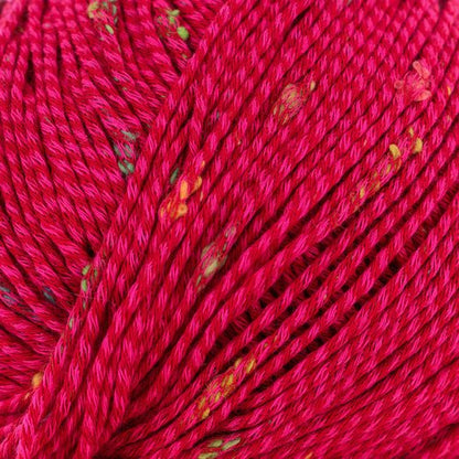 Close-up of bright pink yarn with small multicolored specks woven into it. The yarn is tightly wound, showcasing its texture and details.