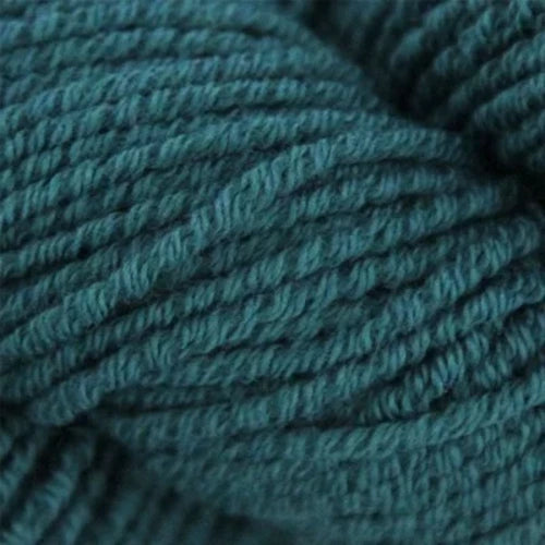 A bowl containing three skeins of yarn. The skeins display different colors: beige, teal, and dark teal. The yarns are neatly coiled and placed side by side in the bowl. The background is white.