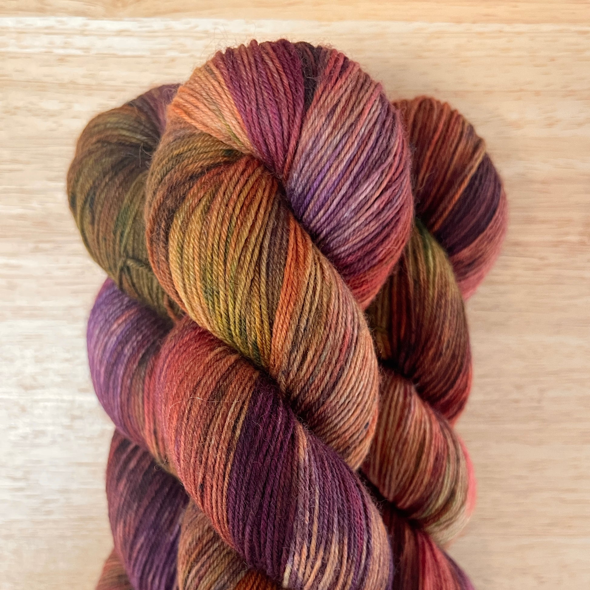 Multicolored skein of yarn on a wooden surface
