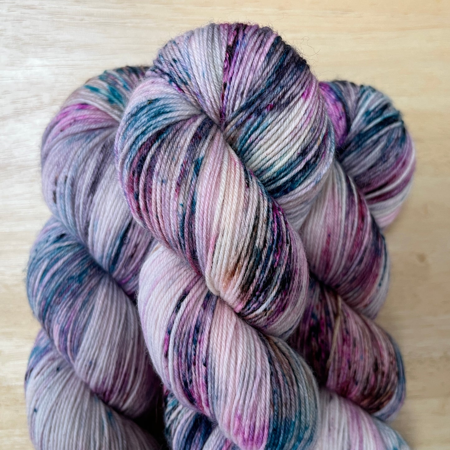 Multicolored skein of yarn on a light wooden surface