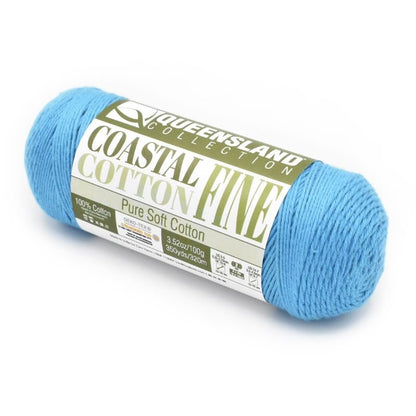 A skein of Queensland Collection Coastal Cotton Fine yarn in light blue. The label indicates it is pure soft cotton, weighing 3.52 ounces (100 grams) and measuring 350 yards (320 meters).