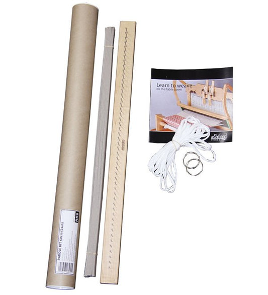 The image shows a weaving starter kit. It includes a cardboard tube, a flat wooden piece with teeth-like notches on one edge, a booklet titled "Learn to Weave," a bundle of white string, and two metal rings.