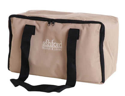 A rectangular beige bag with black handles and a zipper on top. The bag has "ashford WHEELS & LOOMS" printed in white on the front.