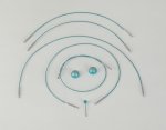 An arrangement of blue cords and connectors on a white background. Four curved cords are placed in a semi-circular pattern, with two teal spherical objects and a small straight cord in the center, resembling a smiley face.