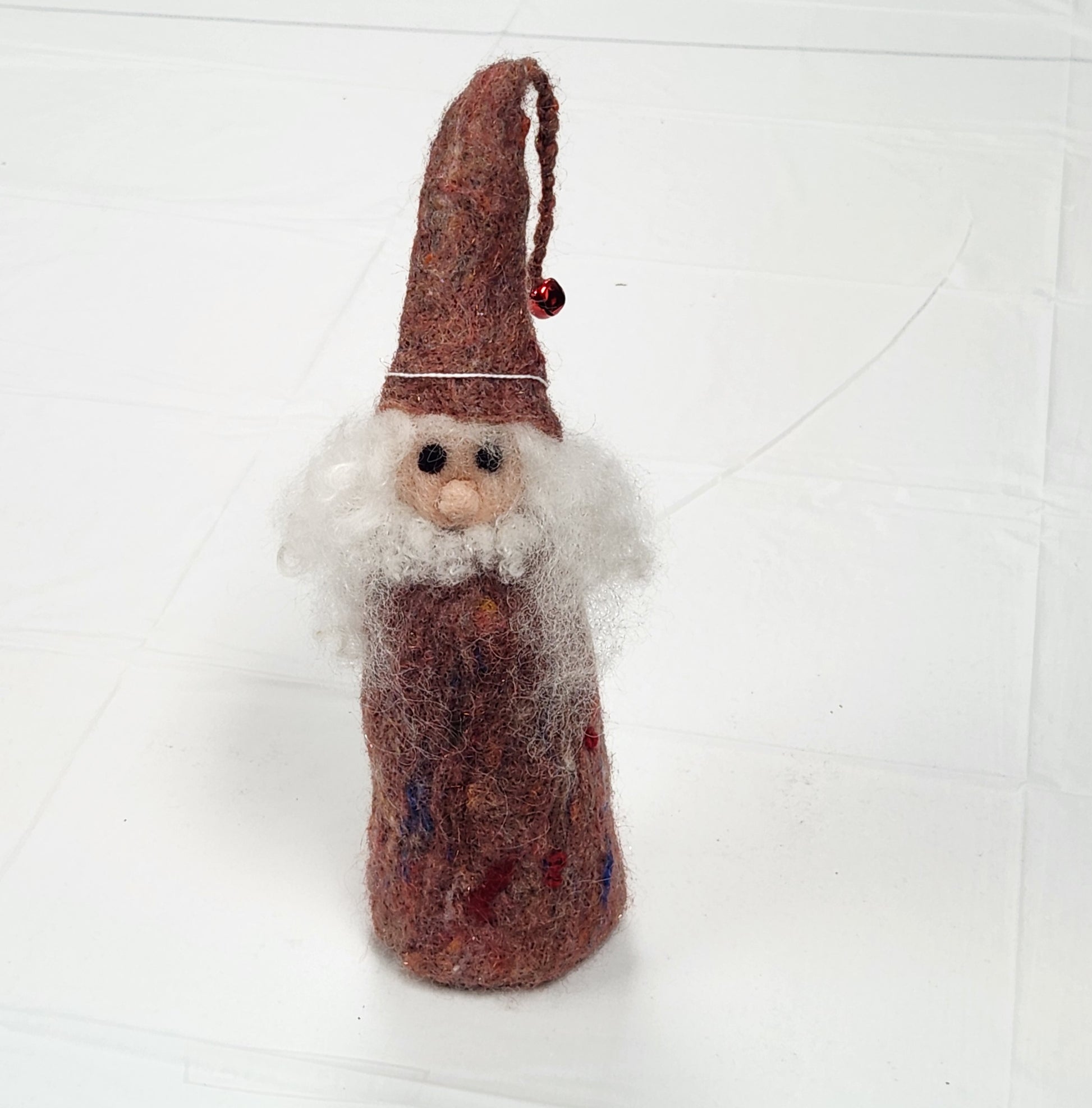 A hand-felted wizard doll with a red hat and blue body, standing against a white background.