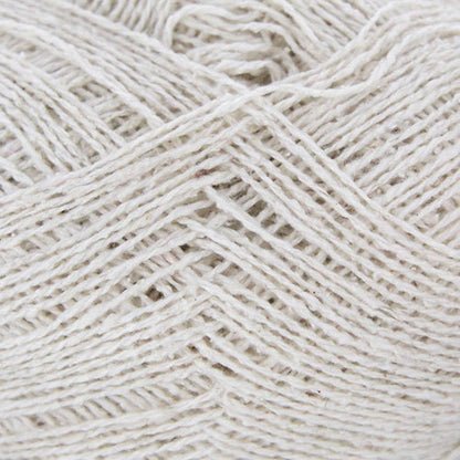 A ball of Berroco Remix Light yarn with a label indicating it is made of 100% recycled fibers. The yarn is light gray.