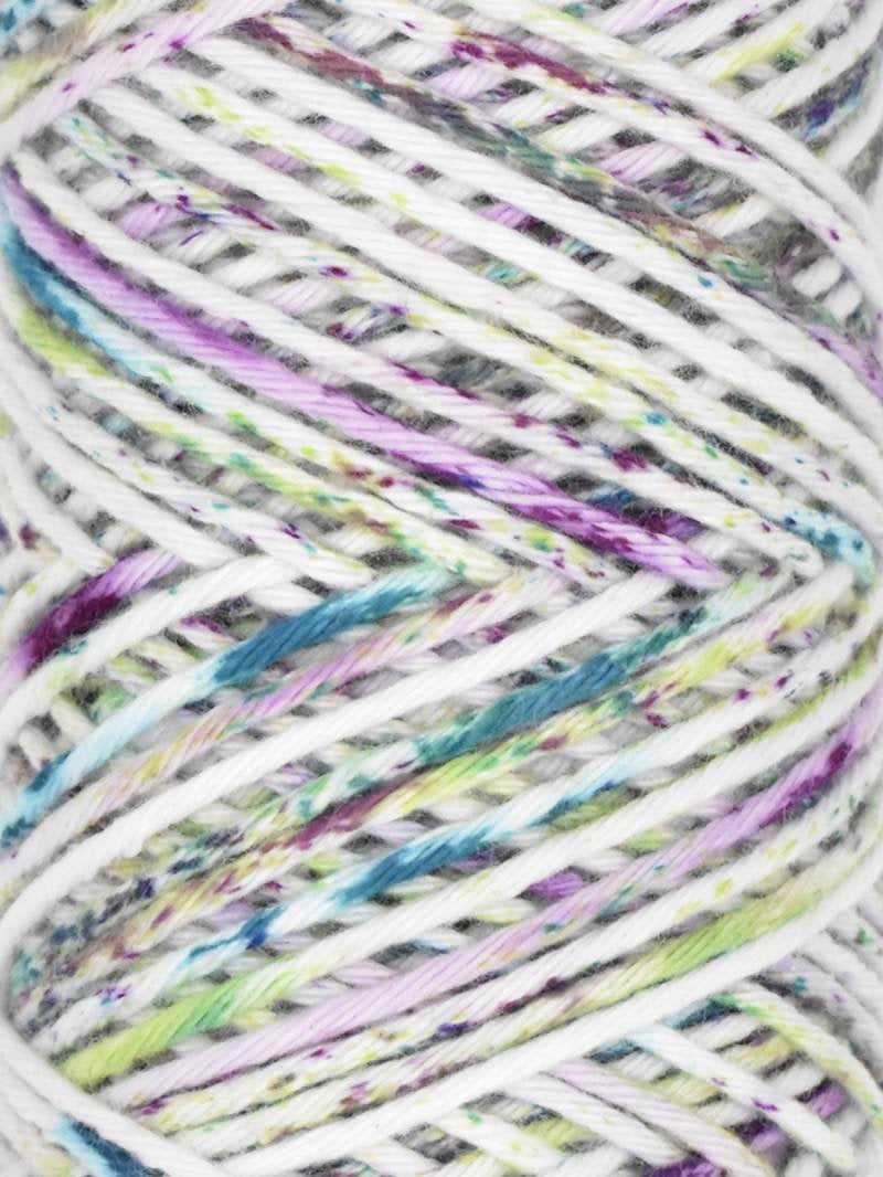 A skein of Queensland Collection Coastal Cotton yarn in the Ocean Mist colorway. The label indicates it is made of 100% pure soft cotton, weighs 100g, measures 170m, and is OEKO-TEX certified. The yarn is multicolored with shades of white, blue, and pink.